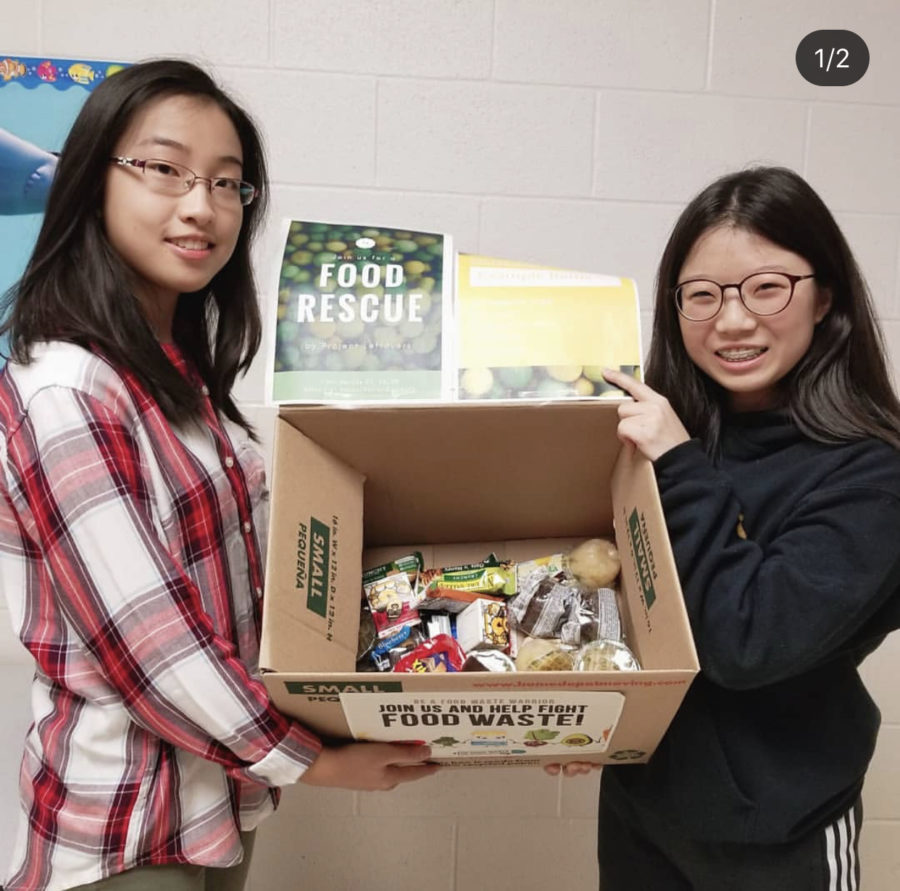 Katherine Dai (left) and Lea Kim (right) standing with a box of collected food items. PC: @projectleftovers on IG