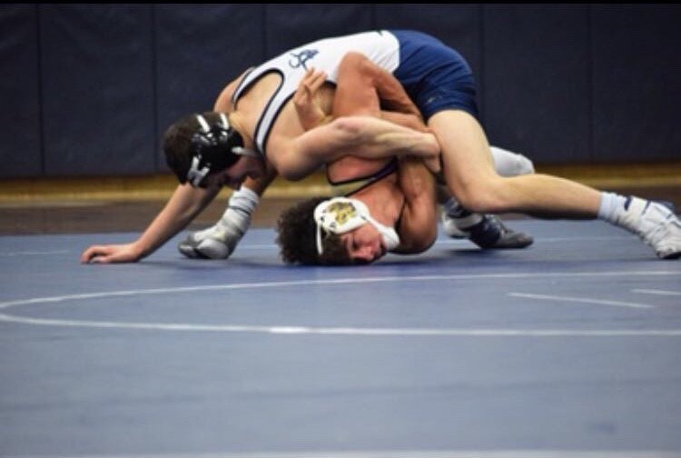 Nathan Leko (on top) wrestling in a Solon duel meet.