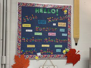 A board in Eastman's classroom that says "Hello!" in different languages.
