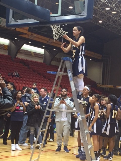 Sophomore Mariah Modkins cuts down the net following her game winning free throws for the Lady Comets.