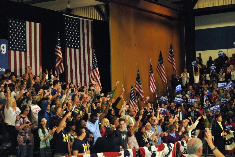 Clinton supporters screamed in encouragement and waved flags as nearby news anchors announced the Secretary's predicted victory at the Michigan Democratic primaries, a contention that was later disproven when Sanders won in a major upset.