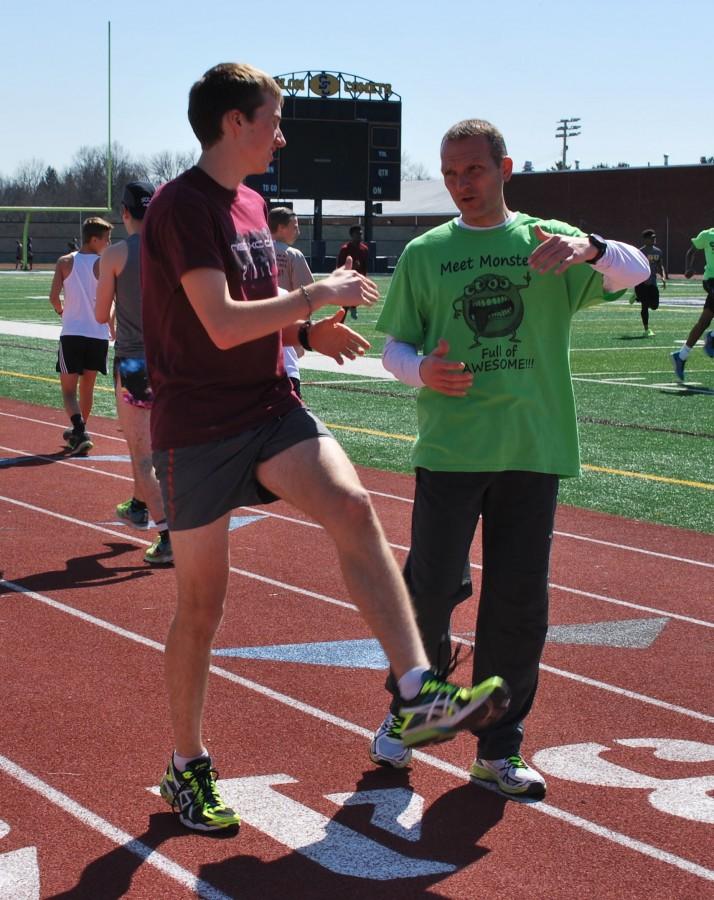 Coach Sabol talks to junior runner Joe Riordan about his workout.