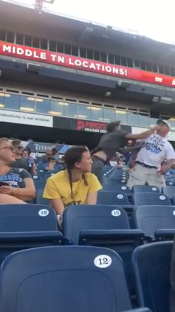 A fight breaking out between fans in the stadium.