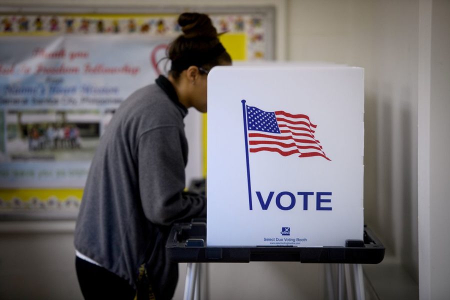 A woman casts her vote in Cambridge, Ohio. Photo Credit: https://cdn.vox-cdn.com/thumbor/z5A7HND5N1T6lyF8uT6a-e0aOHE=/0x0:3600x2400/1200x800/filters:focal(1290x826:1866x1402)/cdn.vox-cdn.com/uploads/chorus_image/image/62208063/GettyImages_1058143760.0.jpg