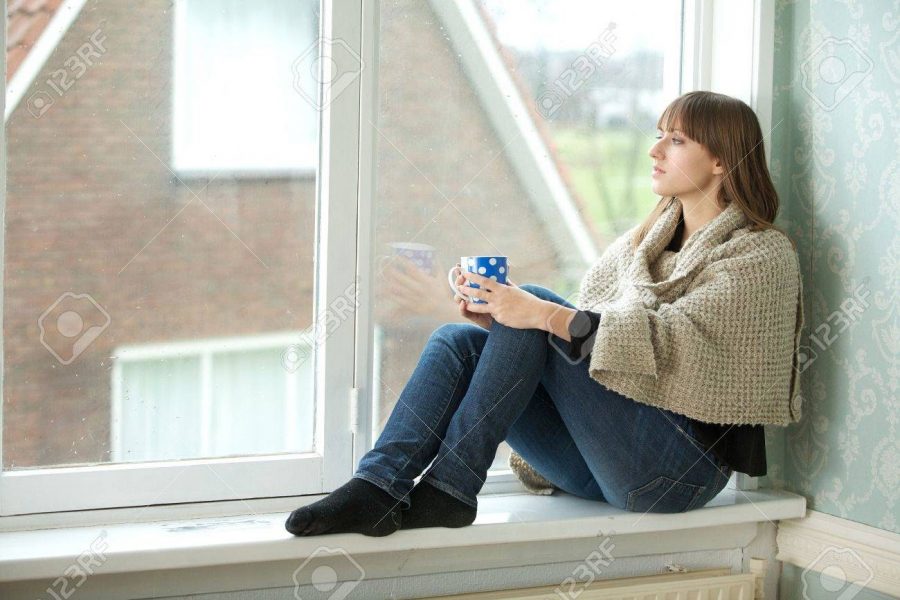 Portrait of young woman looking out window 