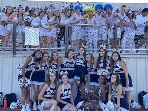 The cheer team, the spirit boys and onlookers of the game, pose for a photo. 