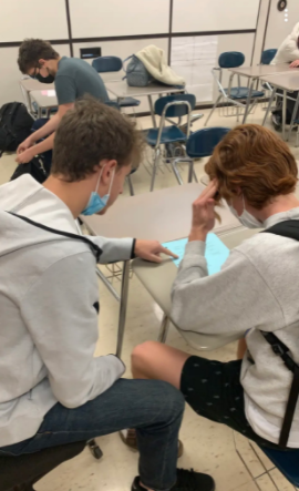 Peer leader Jordan Blaugrund helps a student on a math problem in Ms. Moeschberger's classroom.