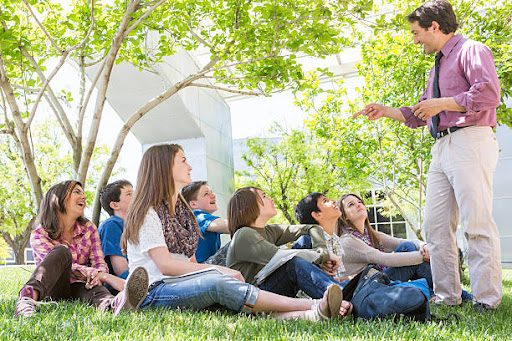 A teacher teaches students outdoors.