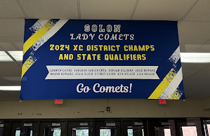 A banner hangs in the Pool Lobby congratulating the Girls Cross Country team on their success. 