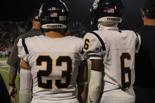 Photo of Michael Fry, 23, and Elijah Woodard, 6, standing on the sidelines. Photo taken by Mady Leutchtag