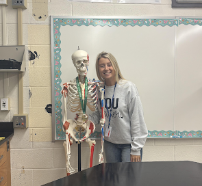 Ms. Chessar poses with her classroom skeleton.