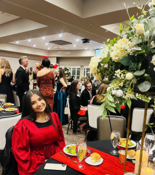 Egzait seated at her table at the American Heart Association's Heart Ball event. Photo taken by Egzait's counselor, Katie Thom.