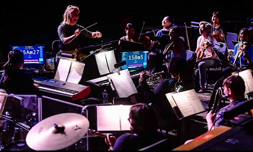 Sarah Behal conducting "The Little Mermaid" orchestra pit. 